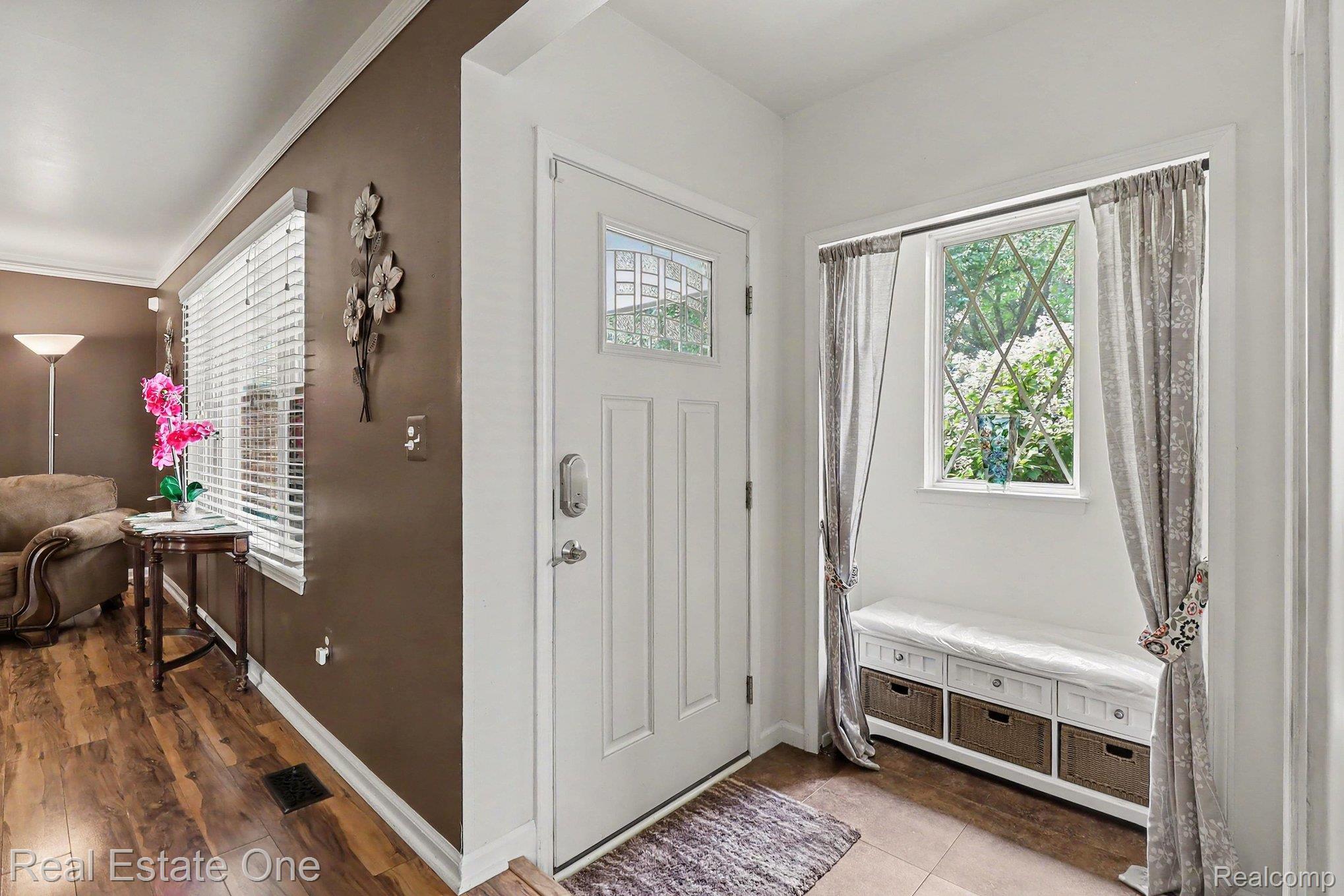 6570 Edgewood Road Canton, MI 48187 - Photo 3 of 22 Entryway featuring a paneled door with decorative glass insert, tiled flooring, and a built-in bench with storage baskets
