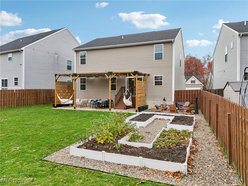 228 Stone Ridge Way Berea, OH 44017 - Photo 40 of 44 Back of house featuring a patio, a fenced backyard, a pergola, and a vegetable garden