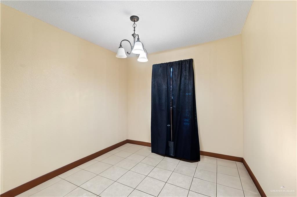 106 Rosa Priego Street Donna, TX 78537 - Photo 9 of 25 Tiled empty room with a chandelier