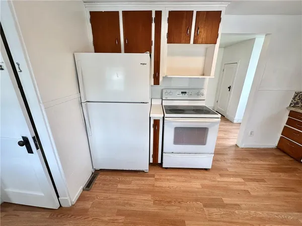 a view of a kitchen with wooden floor and electronic appliances
