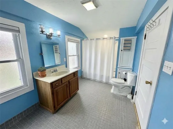 a bathroom with a sink a toilet and a mirror
