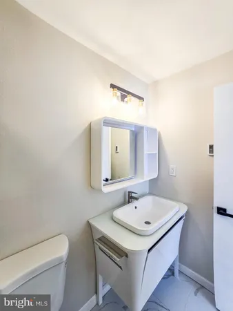 a bathroom with a sink a toilet and mirror