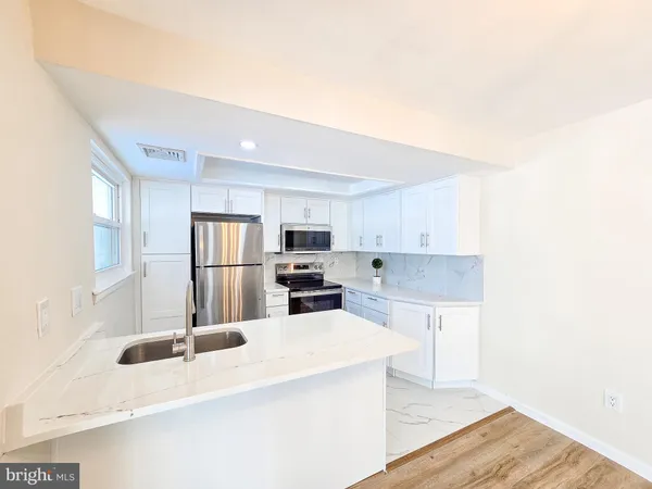 a kitchen with stainless steel appliances a sink and a refrigerator