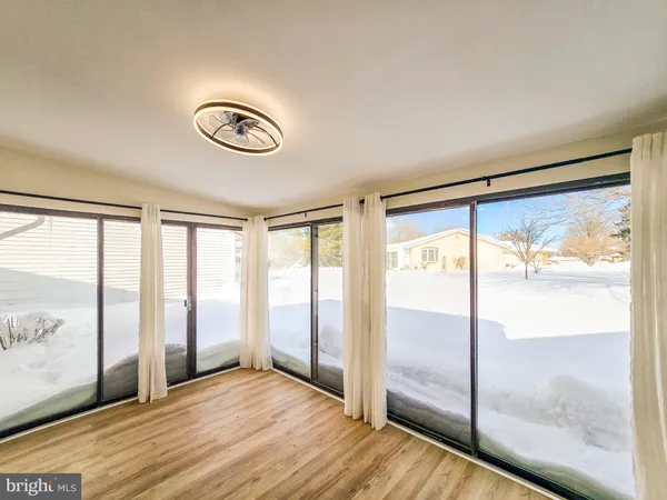 a view of a room with wooden floor and windows