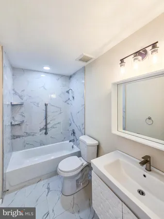 a bathroom with a toilet a sink and bathtub