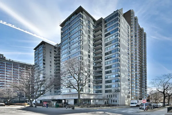a front view of a building with lot of trees
