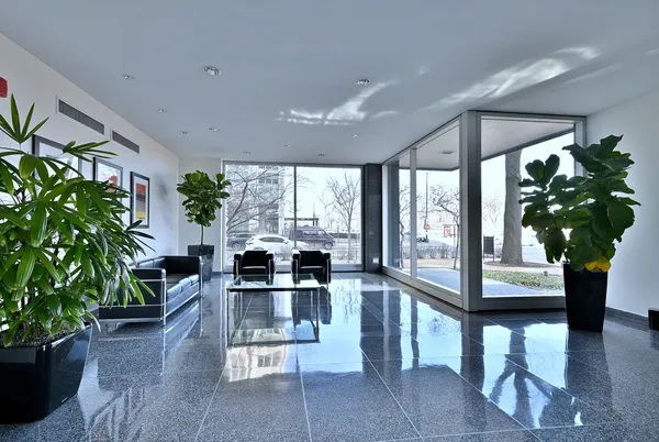 a living room with furniture a potted plant and a large window