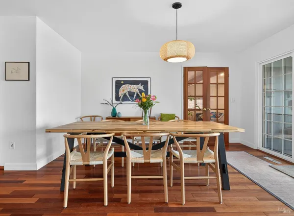 a dining room with furniture window and wooden floor