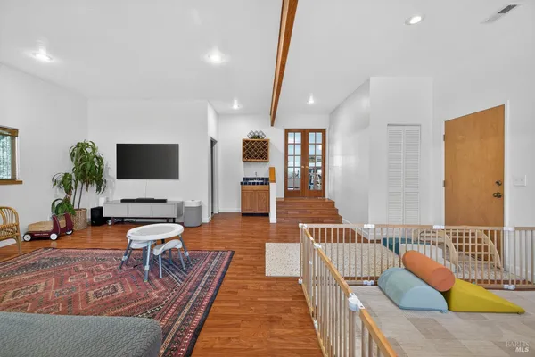 a living room with furniture wooden floor and a flat screen tv