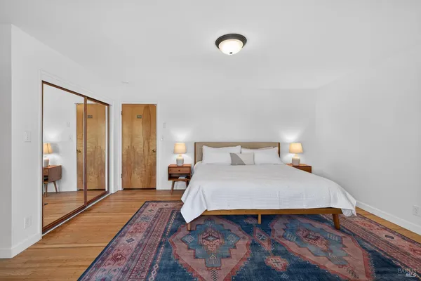 a bedroom with a bed and wooden floor