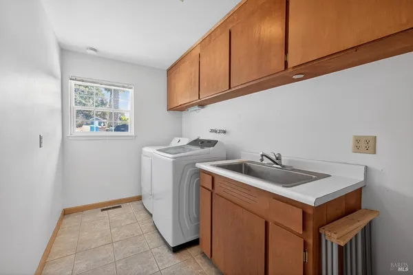 a utility room with sink dryer and washer