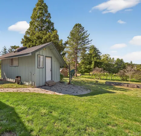 a view of a house with a yard and sitting area