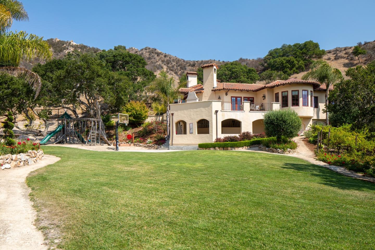 14501 Roland Canyon Road Salinas, CA 93908 - Photo 49 of 53 a view of a white house in front of a big yard with plants and large trees