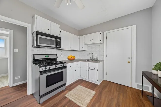 a kitchen with granite countertop cabinets stainless steel appliances and wooden floor