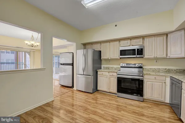 a kitchen with stainless steel appliances a stove a refrigerator sink and microwave