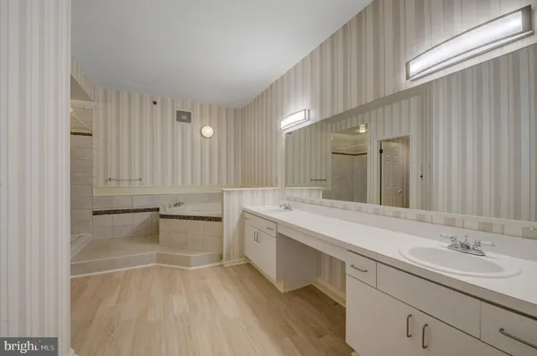 a bathroom with a tub sink and mirror