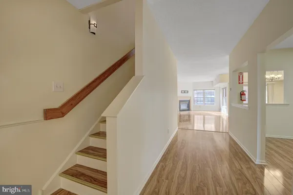 a view of a hallway with wooden floor and staircase