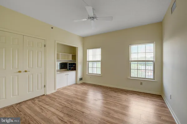 a view of an empty room with window and wooden floor