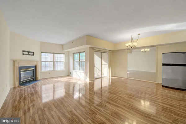 a view of an empty room with a fireplace and wooden floor
