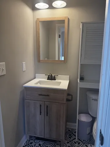 a bathroom with a toilet sink and mirror