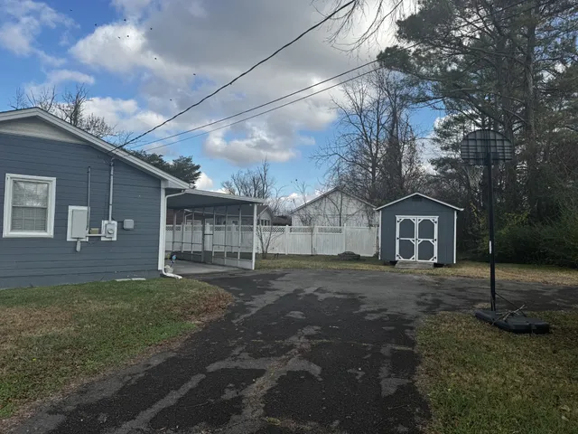 a view of a yard in front of a house with large tree