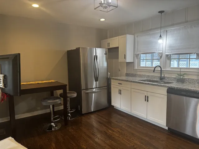 a kitchen with kitchen island a counter top space a sink stainless steel appliances and cabinets