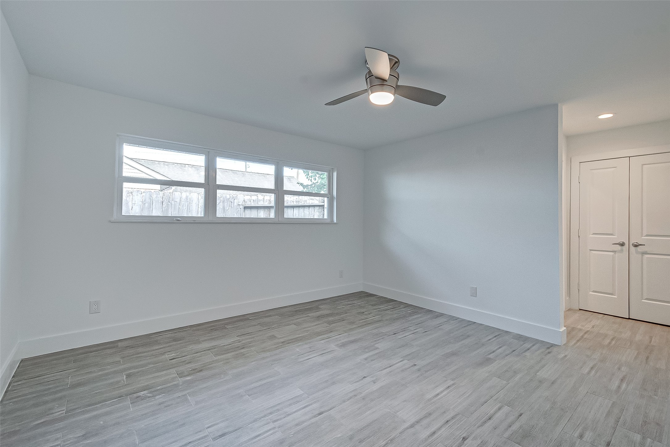 5007 Cheena Drive Houston, TX 77096 - Photo 18 of 40 an empty room with wooden floor fan and windows