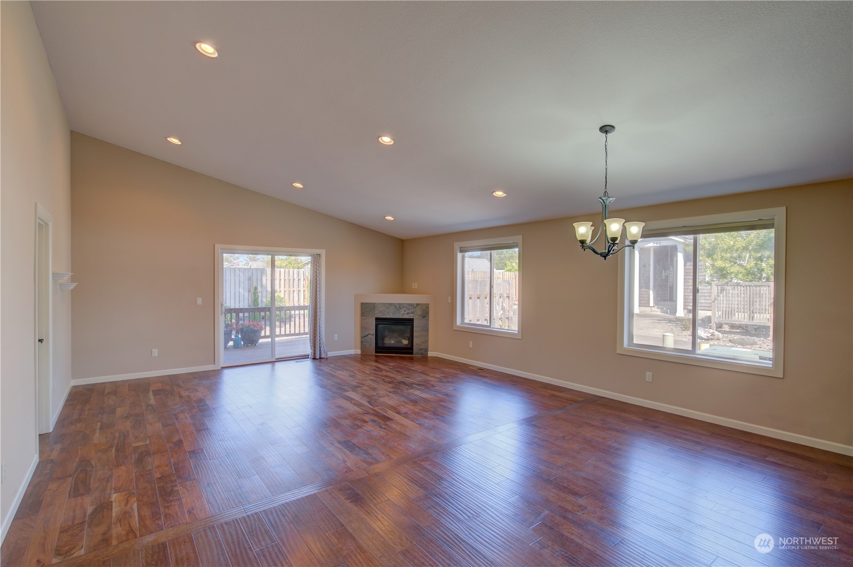 206 Pioneer Road West Long Beach, WA 98631 - Photo 6 of 39 an empty room with wooden floor fireplace and windows