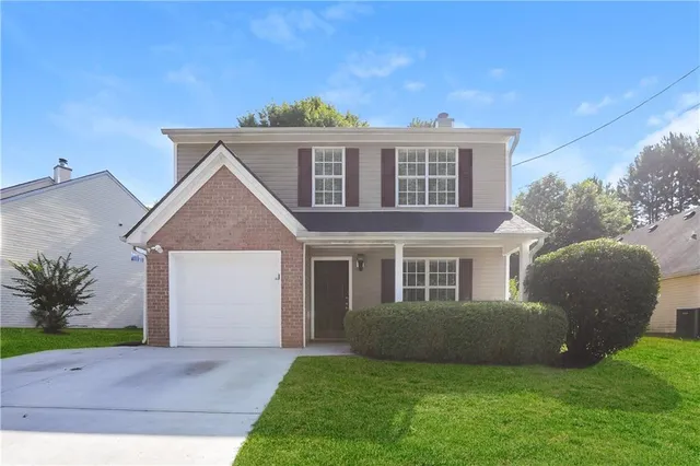 a front view of a house with a garden and yard