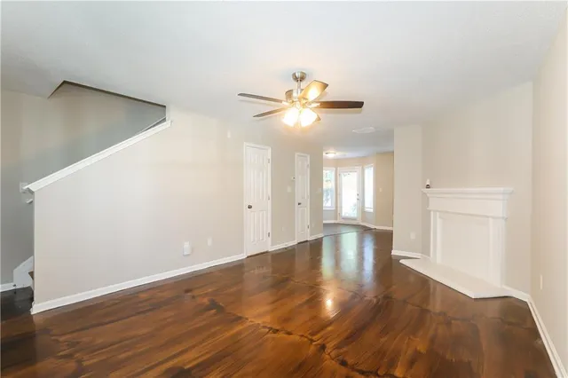 a view of an empty room with window and wooden floor