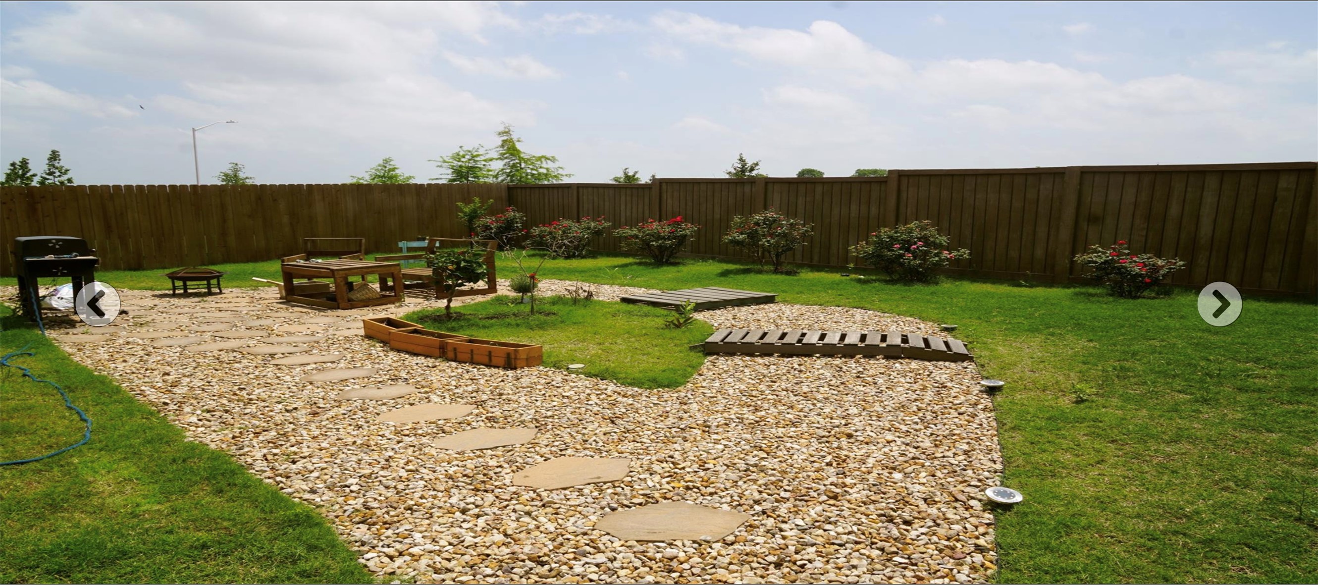 2321 Forgetmenot Lane Manor, TX 78653 - Photo 26 of 27 A private, fenced backyard offers a serene oasis with a gravel path, stepping stones, and lush green lawn.