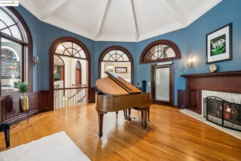 a living room with furniture a fireplace a clock and a large window