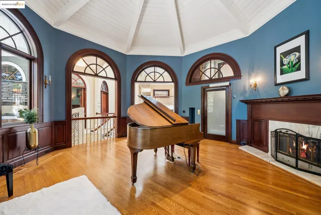 a living room with furniture a fireplace a clock and a large window