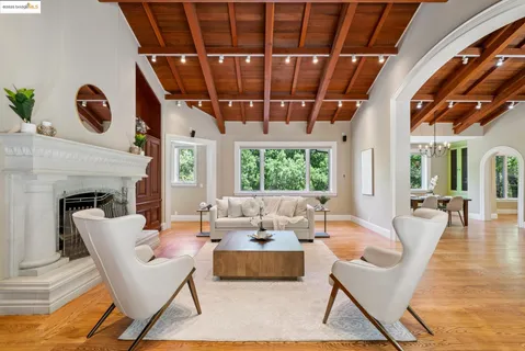 a view of a kitchen with stainless steel appliances granite countertop a stove a refrigerator a dining table and chairs with wooden floor