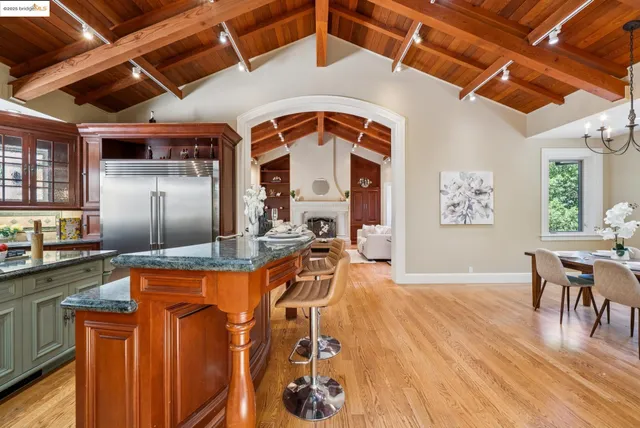 a dining hall with stainless steel appliances granite countertop a stove and cabinets with wooden floor