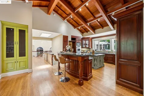 a dining room with wooden floor a chandelier a wooden table and chairs