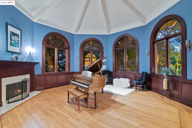 a living room with furniture a fireplace and a large window