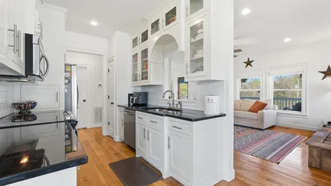 a large white kitchen with stainless steel appliances