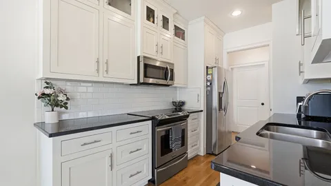 a kitchen with white cabinets and stainless steel appliances