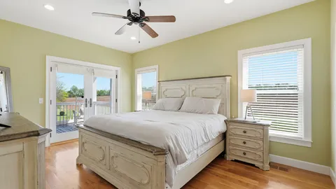 a bedroom with a bed a chandelier and a window
