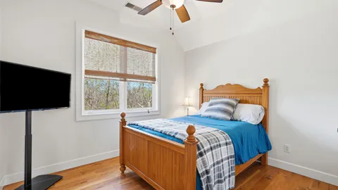 a bedroom with a bed a flat screen tv and a window