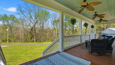 a view of a porch with furniture and a yard