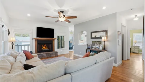 a living room with furniture a flat screen tv and a fireplace