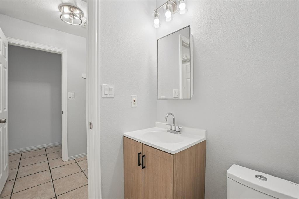 4021 Preferred Place Dallas, TX 75237 - Photo 6 of 25 a bathroom with a sink a toilet and a mirror