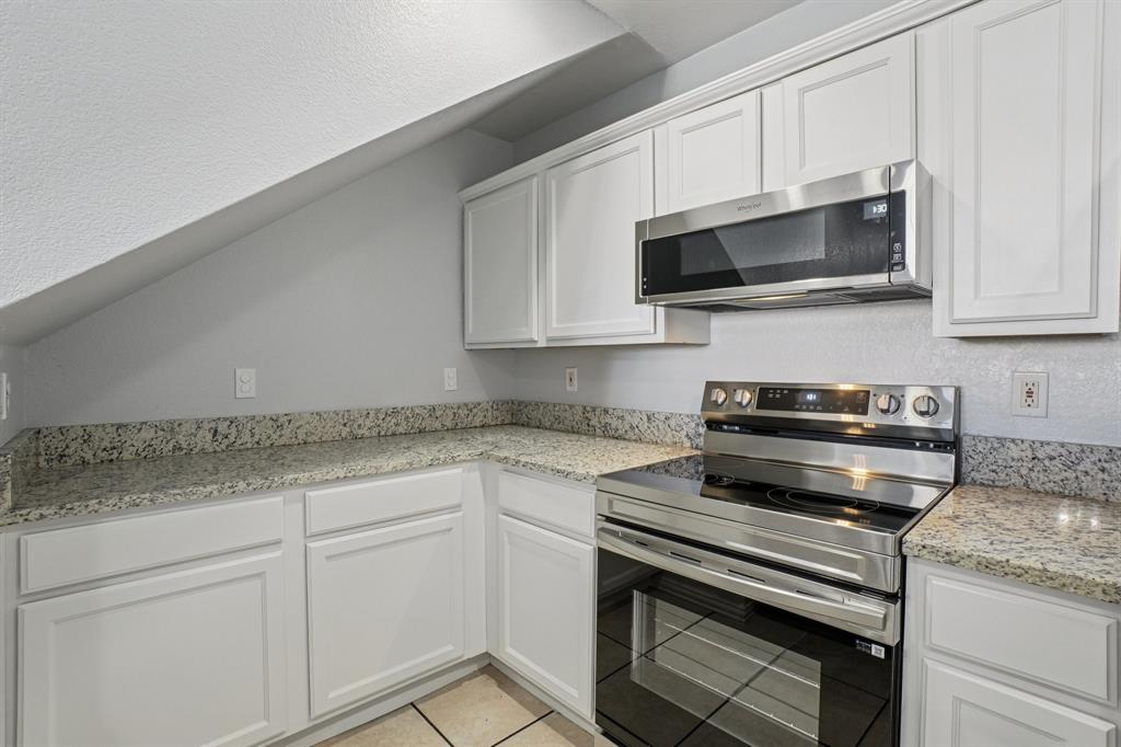 4021 Preferred Place Dallas, TX 75237 - Photo 10 of 25 a kitchen with stainless steel appliances granite countertop grey cabinets and a stove top oven