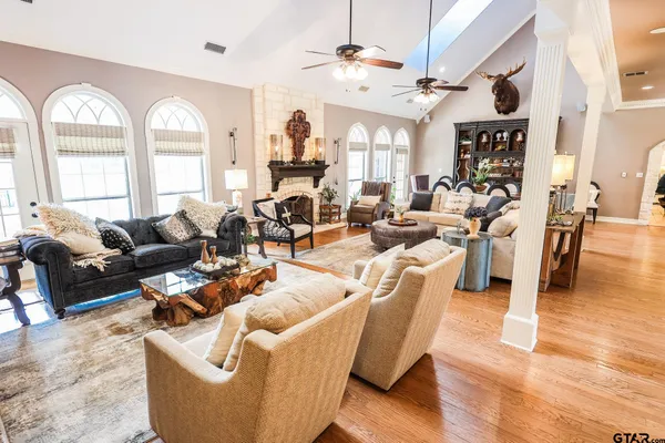 a living room with furniture fireplace and a large window