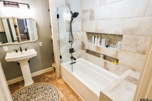 a bathroom with a sink a mirror and a bathtub