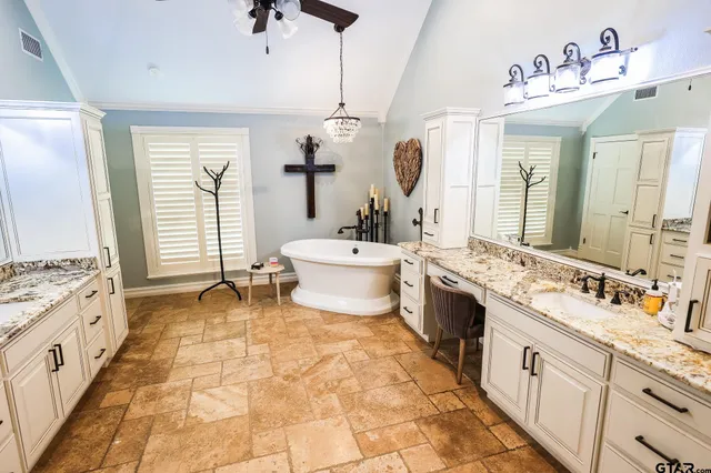 a spacious bathroom with a double vanity sink mirror and bathtub