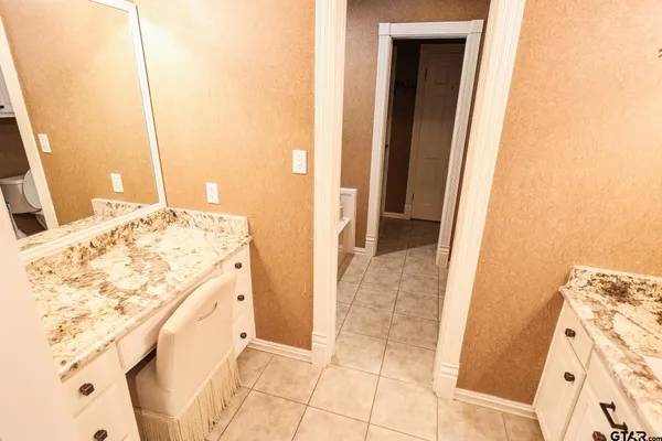a bathroom with a granite countertop sink and a mirror