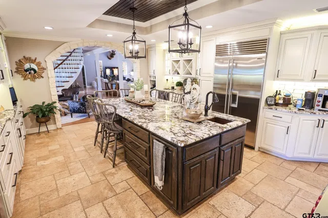 a kitchen with granite countertop a sink a counter top space appliances and cabinets